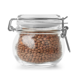 Glass jar with brown lentils on white background