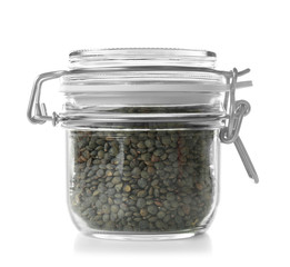 Glass jar with french green lentils on white background