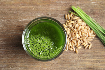 Wheat grass shot and grain on wooden background