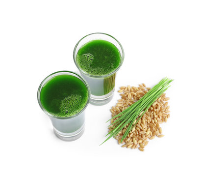 Wheat grass shots and grain on white background