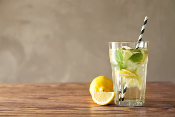 Cold fresh mojito with mint and lemon slices in glass on wooden table