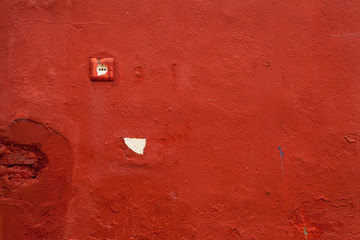 Texture of an old wall socket in a hulling red wall 