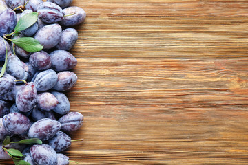 Fresh ripe plums on wooden background