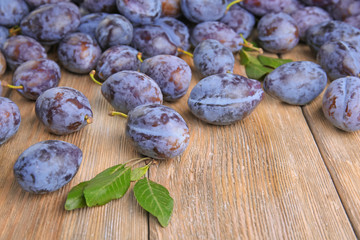 Fresh ripe plums on wooden background