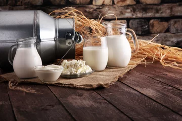 Wall murals Dairy products milk products. tasty healthy dairy products on a table on. sour cream in a bowl, cottage cheese bowl, cream in a a bank and milk jar, glass bottle and in a glass