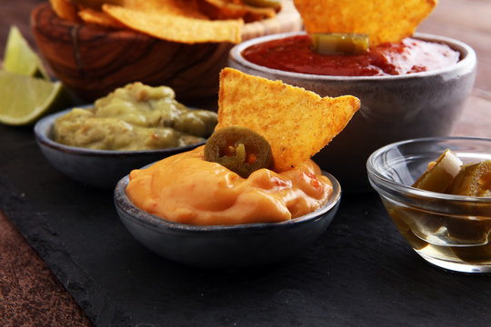 Nachos Tortilla Chips and jalapeÒos Chili Peppers or Mexican chili peppers with Tomato, Cheese and Guacamole dip