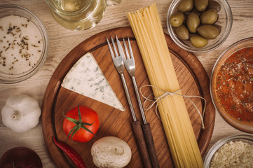 Food ingredients for preparing pasta on wooden kitchen board