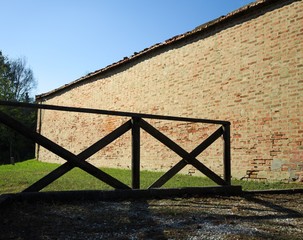 Brick wall behind a wooden fence (Tavullia, Italy)