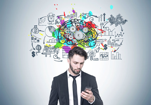 Bearded businessman looking at phone, brain, cogs