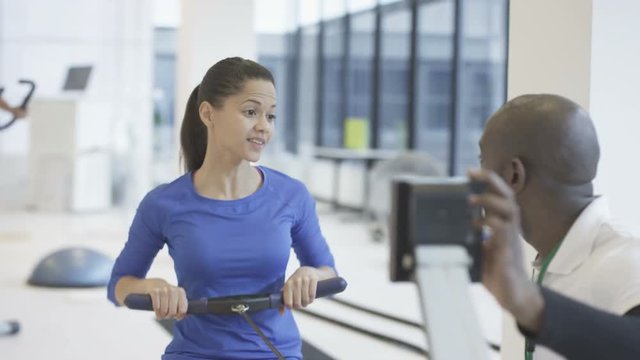 Young group working out in the gym with fitness instructor supervising