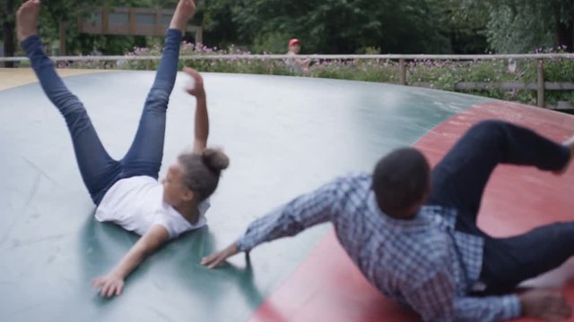  Father & daughter having fun, jumping on inflatable at activity center