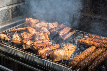 Variety of meat are cooked on a disposable BBQ set