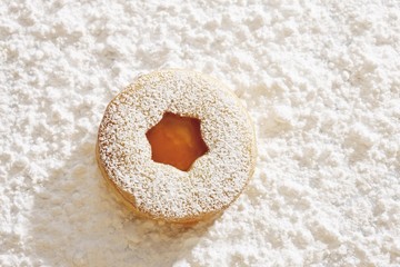 Short pastry jam biscuit, on icing sugar