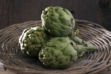Obraz premium Three artichokes (Cynara cardunculus) in a basket