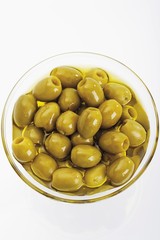 Pitted green olives in a glass bowl
