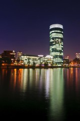 Skyline of Frankfurt with Westhafen Tower and Friedensbruecke bridge from the south-west bank of the Main river, at night, Frankfurt am Main, Hesse, Germany, Europe