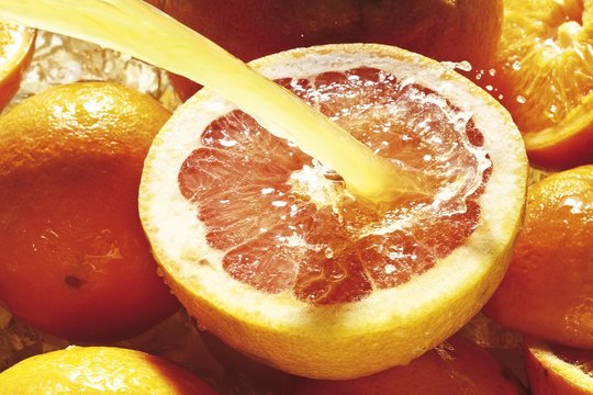 Citrus fruits under jet of juice