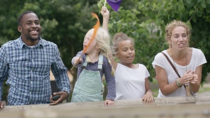  Happy mixed race family at outdoor activity center watching a race & cheering