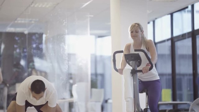 Fit group working out in the gym, video screen showing moving outdoor scene