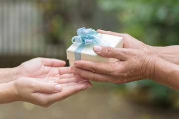 Silver gift box in hand for giving in holidays