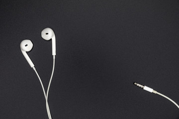 Top view of White Earphones on Black background. Copy space. Music is my life concept
