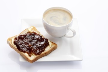 Porcelain plate with a cup of coffee and toast with rhubarb jam