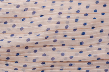 Pink fabric background with blue polka dots.