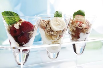 Muesli with yoghurt and fruit in small glass jars