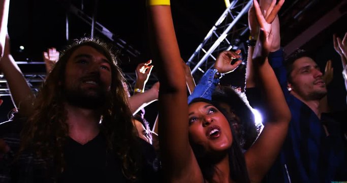 Group of mixed-race people dancing at a concert 