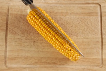 Corn or maize cob with kitchen knife