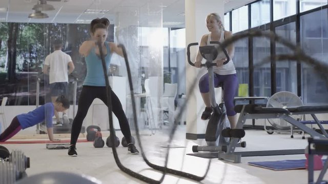 Fit group working out in the gym, video screen showing moving outdoor scene