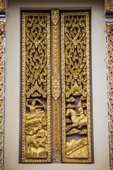 Carved wooden door in a temple Thailand was created by faith in Buddhism.