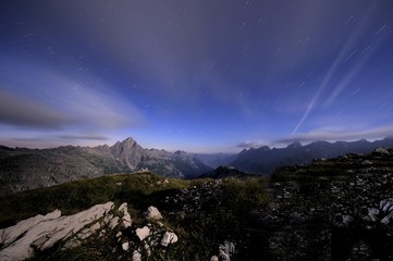 Obraz na płótnie Canvas Mountain range under a full moon and star trails, Hinterhornbach, Lechtal, Ausserfern, Tyrol, Austria, Europe