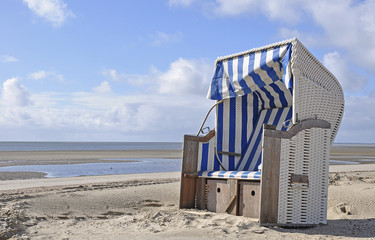 Fototapeta na wymiar Canopied beach chair on the North Sea coast, Wyk auf Foehr, Schleswig-Holstein, Germany, Europe
