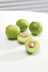 Green plums, whole and halved