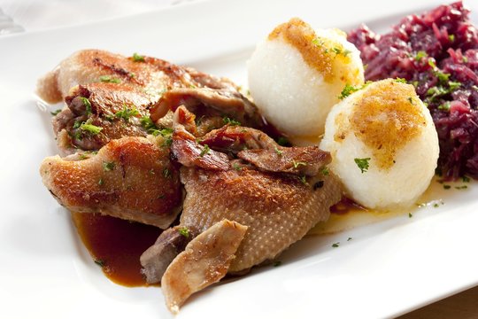 Half a roast duck with dumplings and red cabbage