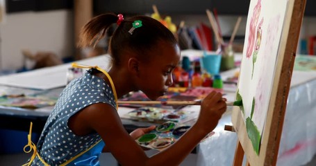 African American cute schoolgirl painting on canvas - Powered by Adobe