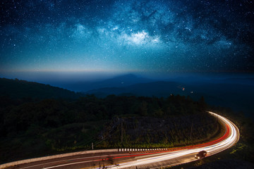 Night road illuminated by car with the milky way galaxy in background © pom669