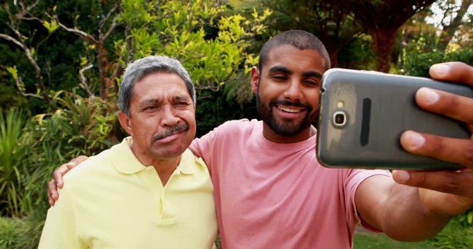 Father and son taking selfie with mobile phone 