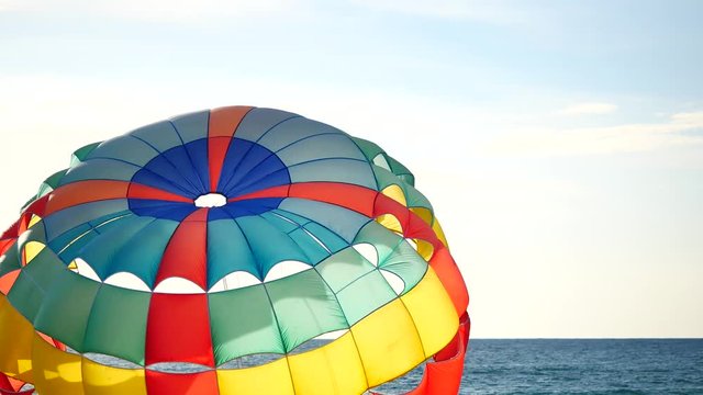 Close up Colorful parasailing provide services to tourists on sky in sunset time in travel and transport concept.