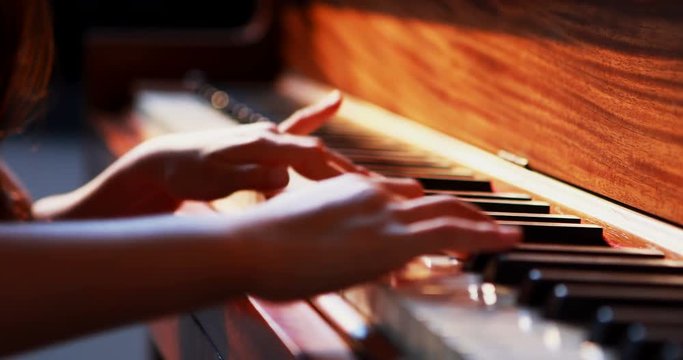 Schoolgirl learning piano in music class 