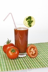 Tomato juice in a glass with tomatoes and lemon