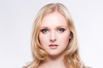 Naklejka premium Portrait einer hübschen blonden jungen Frau vor weissem Hintergrund
