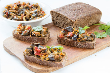 sandwiches with eggplant caviar and coriander leaves on wooden board