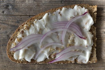 Slice of bread with lard and roasted and red onions