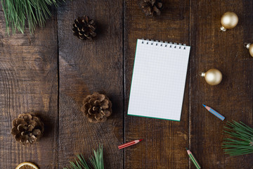 Christmas background with small notebook, decorations on dark wooden table