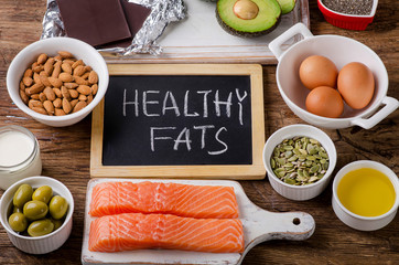Selection of healthy fat sources on wooden background