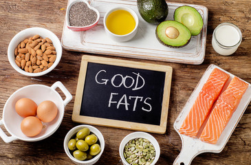 Selection of healthy fat sources on wooden background