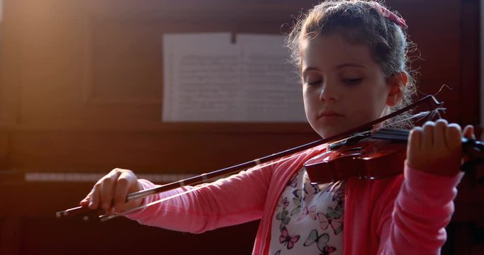 Schoolgirl playing violin in music class 