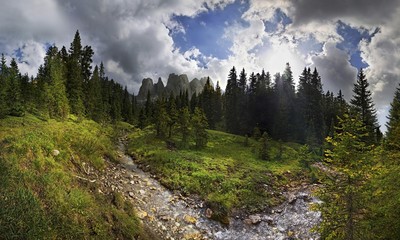 Obraz premium Mountain forest with a small creek, Geisler Group, Odle Mountains at Ranui, Santa Maddalena, Villnoess or Funes Valley, Dolomites, South Tyrol, Italy, Europe